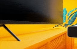 Image of a sound bar being placed under a TV 